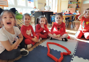 Dzieci siedzą przy ułożonym z klocków sercu